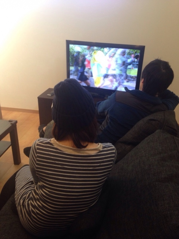 ソファーでテレビを見る夫婦