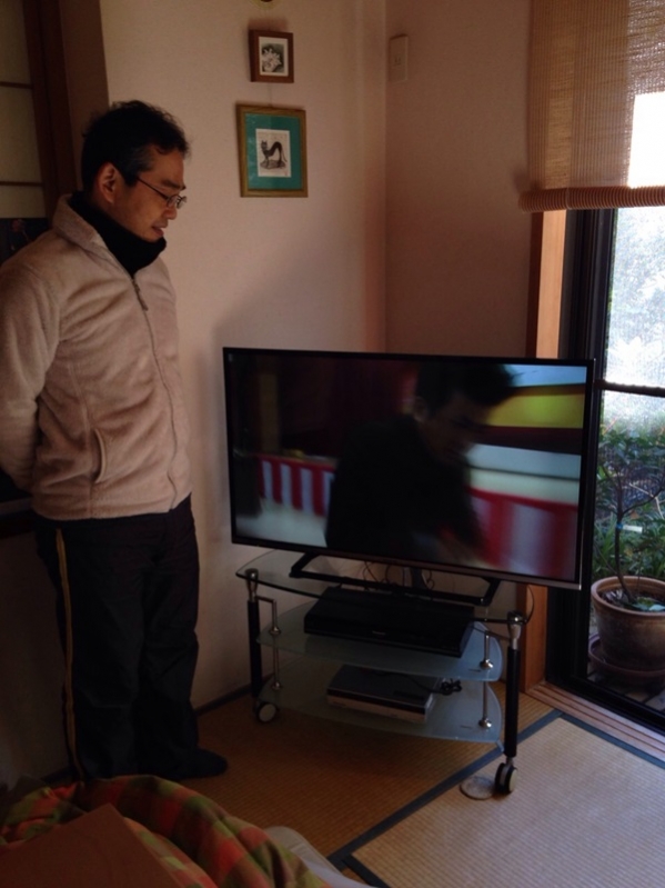 テレビ横の男性