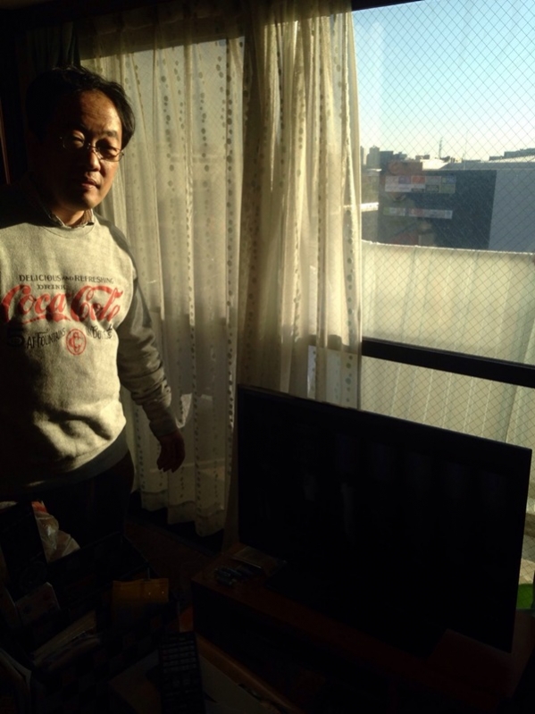 テレビ横の男性