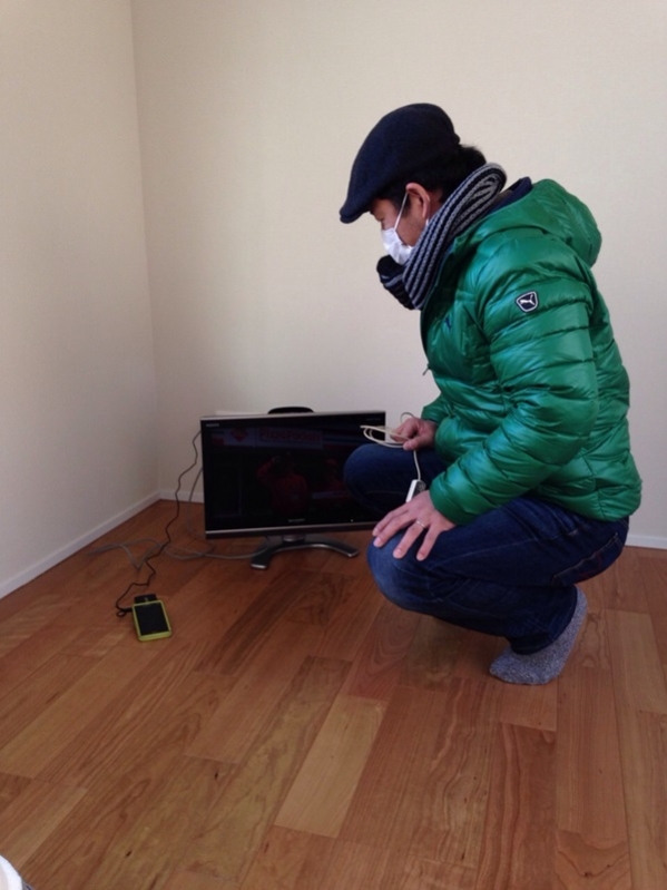 テレビ前でしゃがんでいる男性