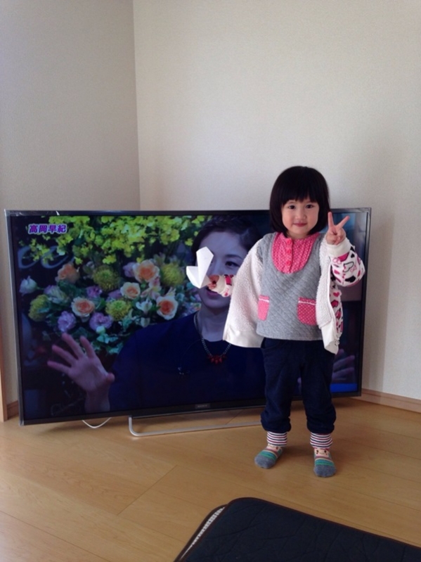 テレビ前でピースする少女