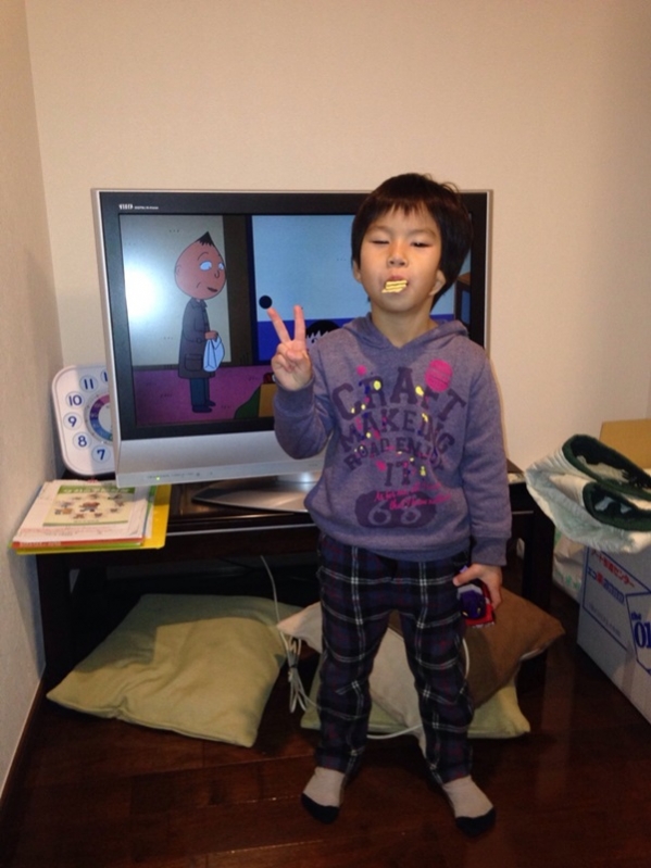 テレビ前でピースする少年