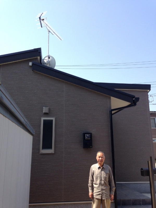 アンテナを設置した戸建住宅前の男性