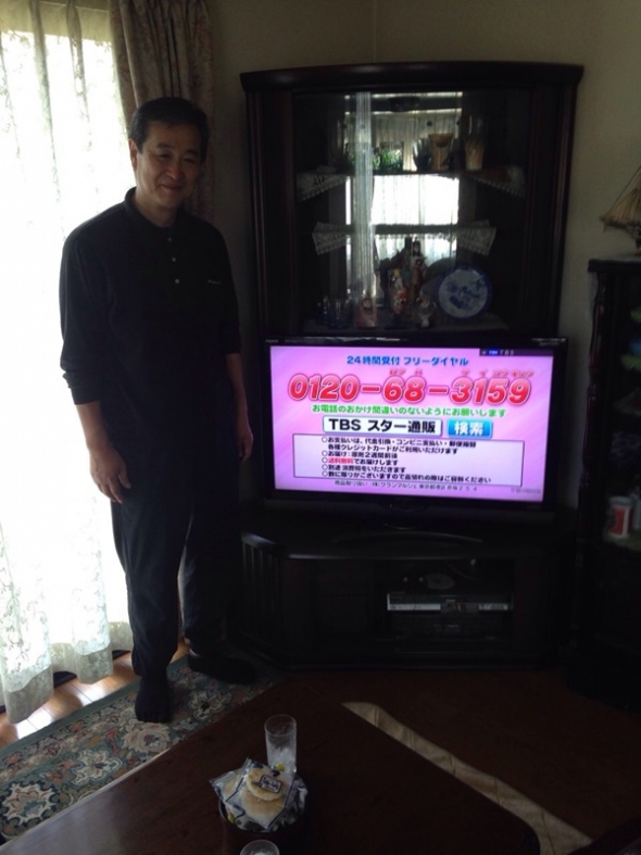 テレビ横の男性