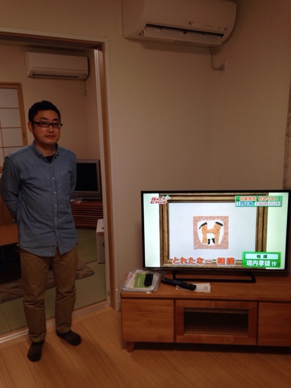 テレビ横の男性