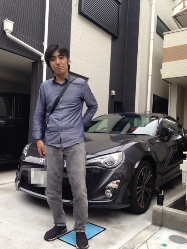 乗用車前の男性