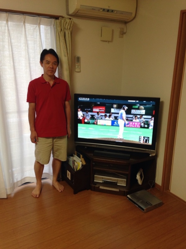 テレビ横に立つ男性