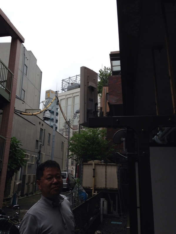 デザインアンテナ横に立つ男性