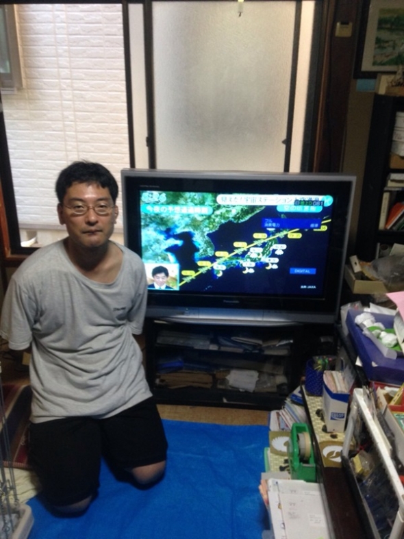 テレビ横の男性