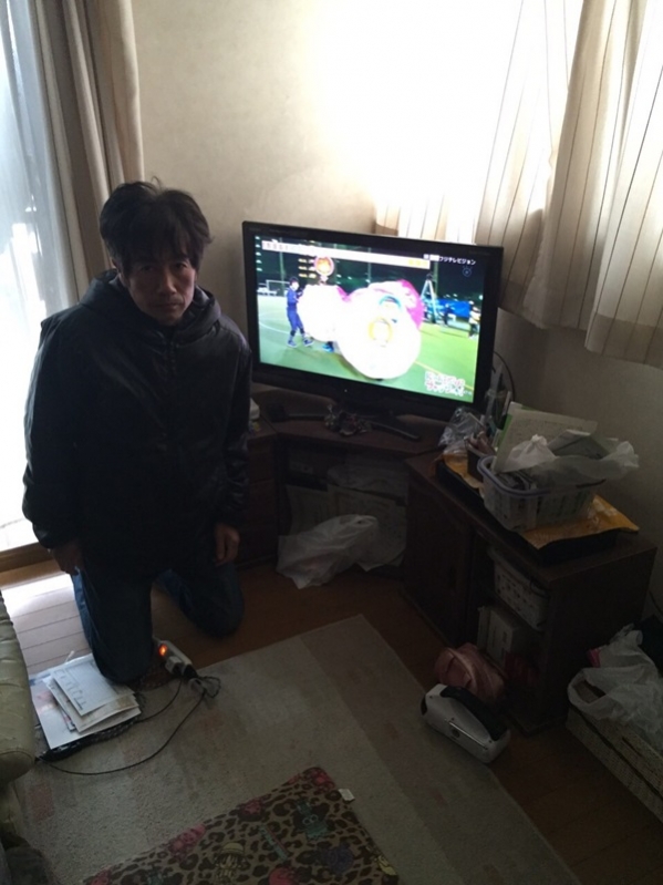 テレビ横の男性