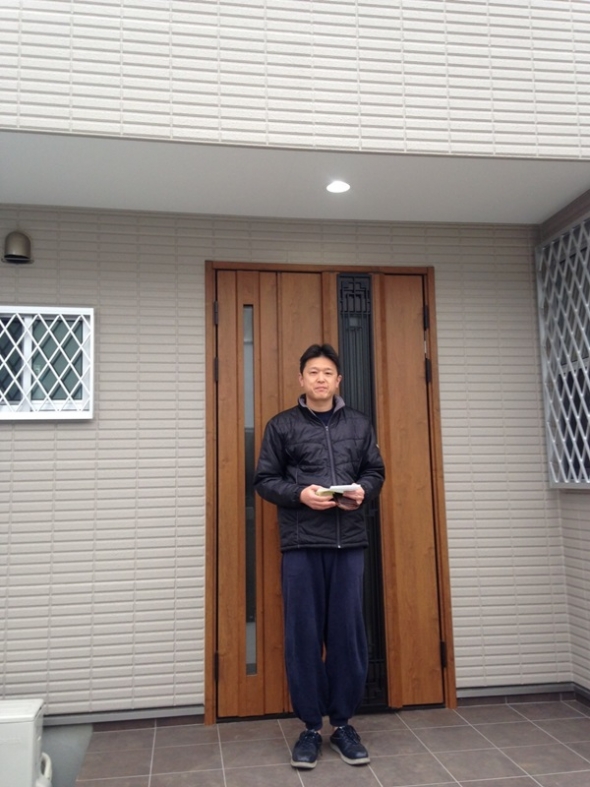 玄関ドア前の男性