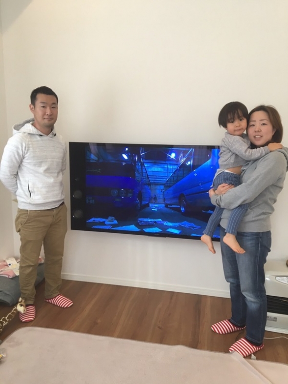 壁掛けテレビ前の家族