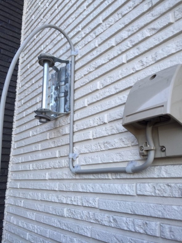 外壁に取り付けた壁面取付金具と引込口の配線