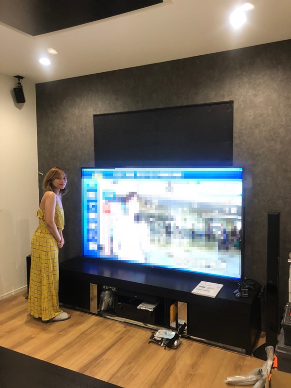 テレビ横に立つ女性