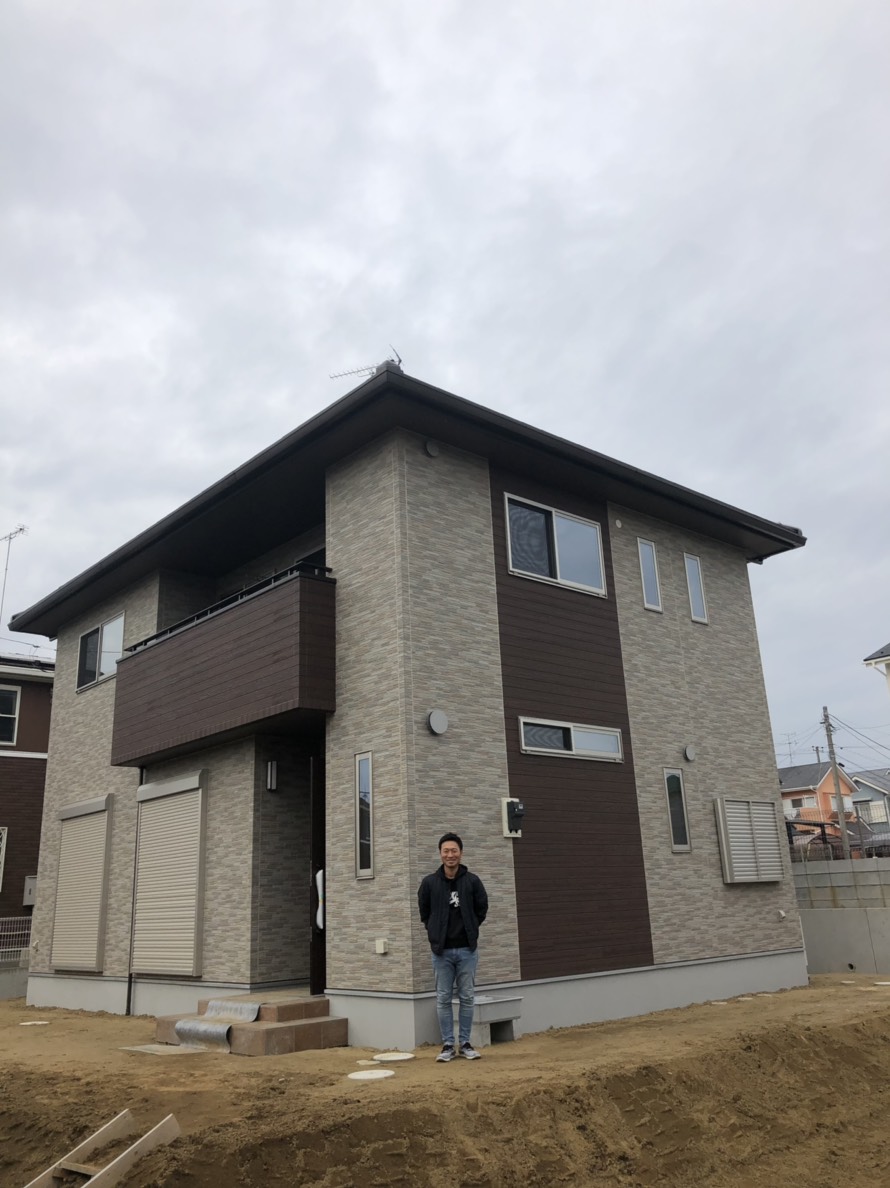 戸建住宅の前に立つ男性