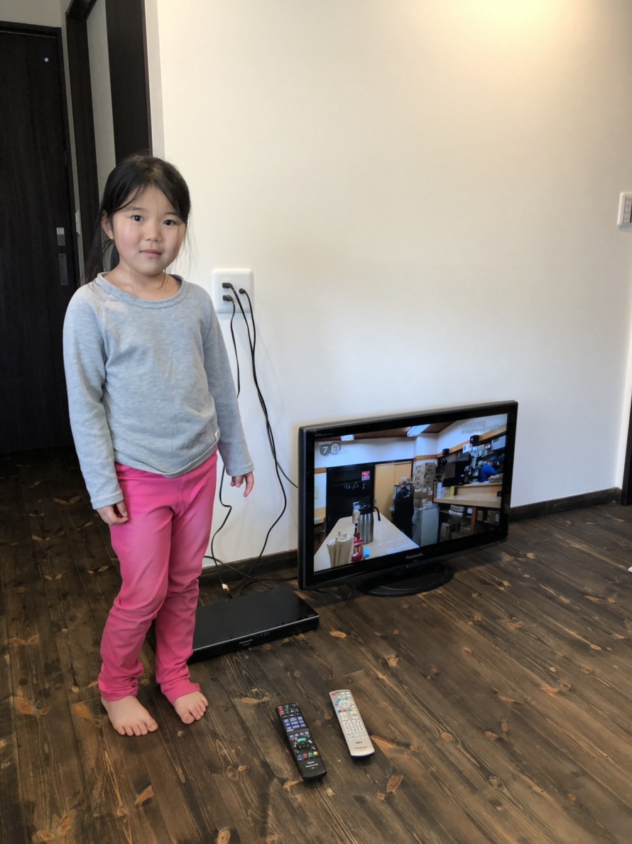 テレビの横に立つ少女