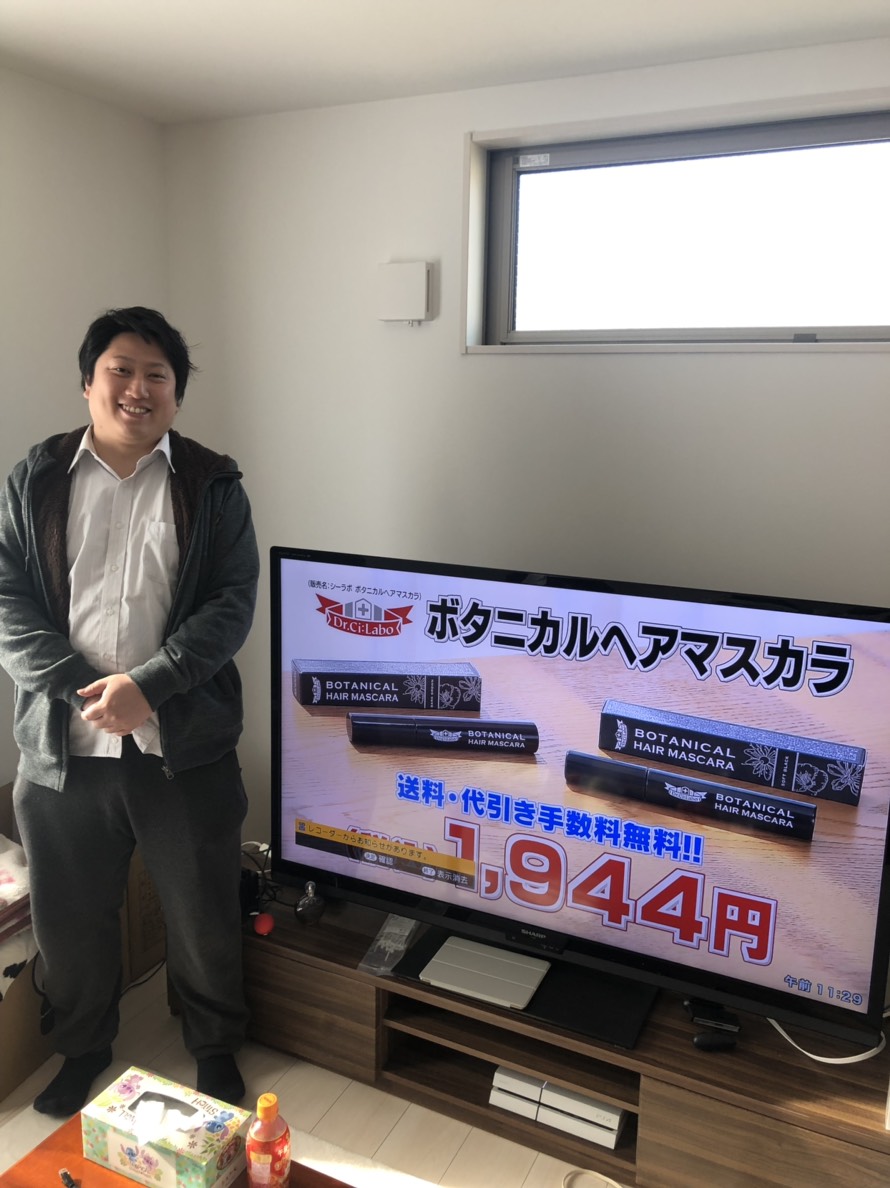 テレビの横に立つ男性