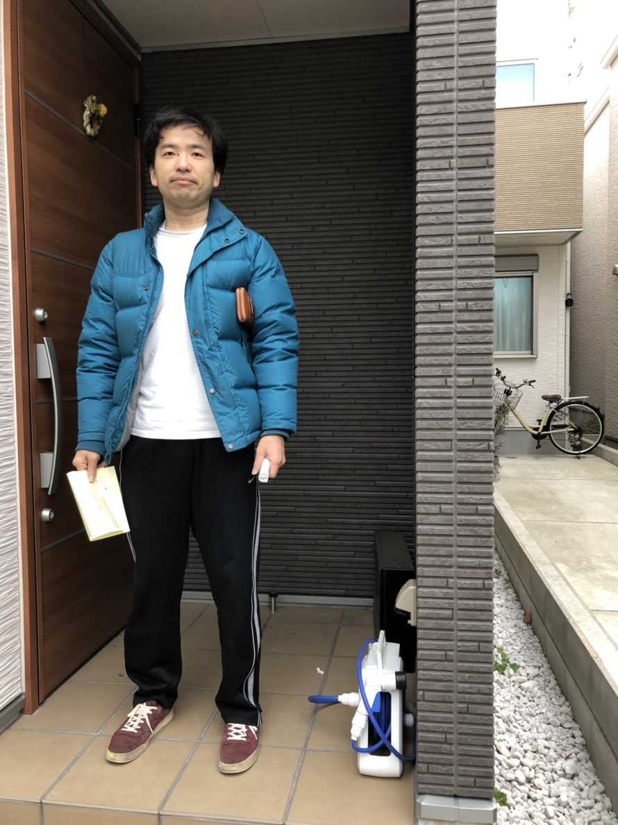 玄関前に立つ男性