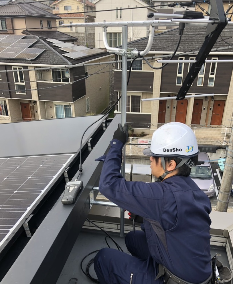 破風板にUHFアンテナを取り付けている作業員