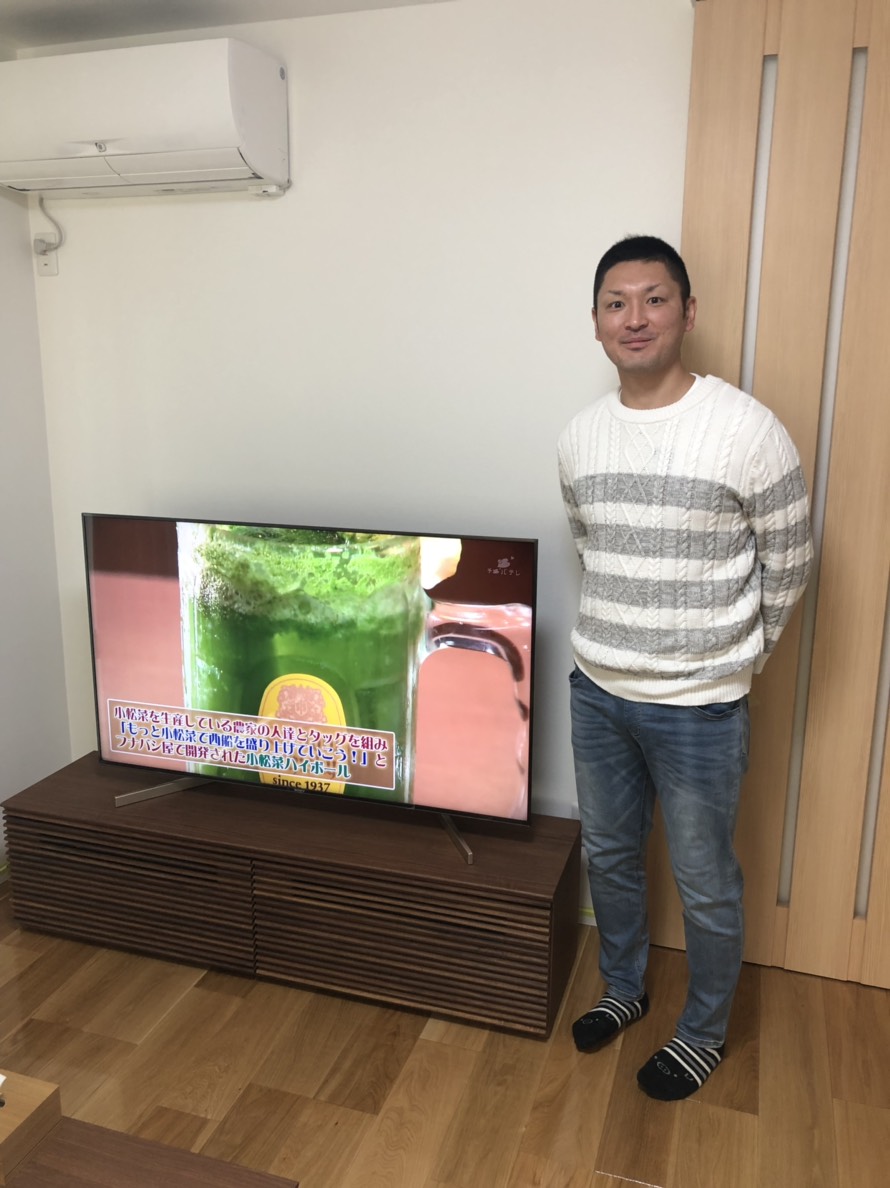 テレビの横に立っている男性