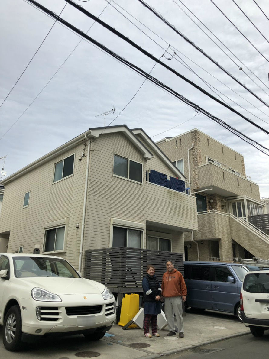 戸建住宅の前に立つ夫婦