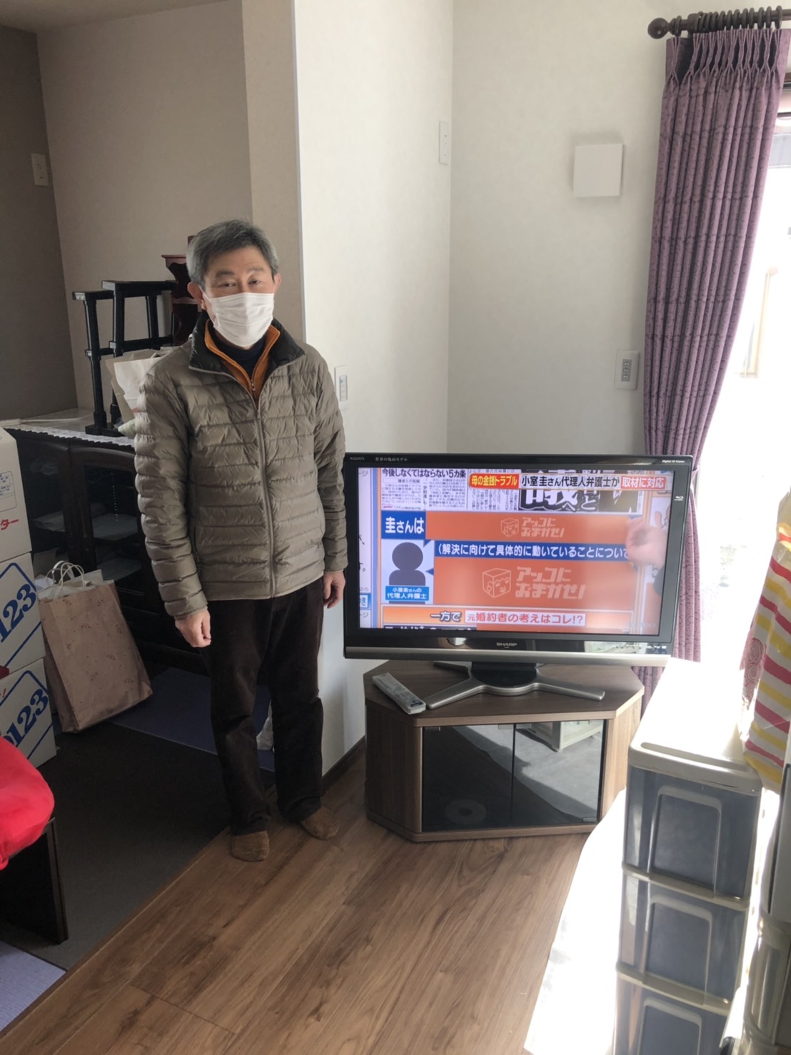 テレビ横に立つ男性