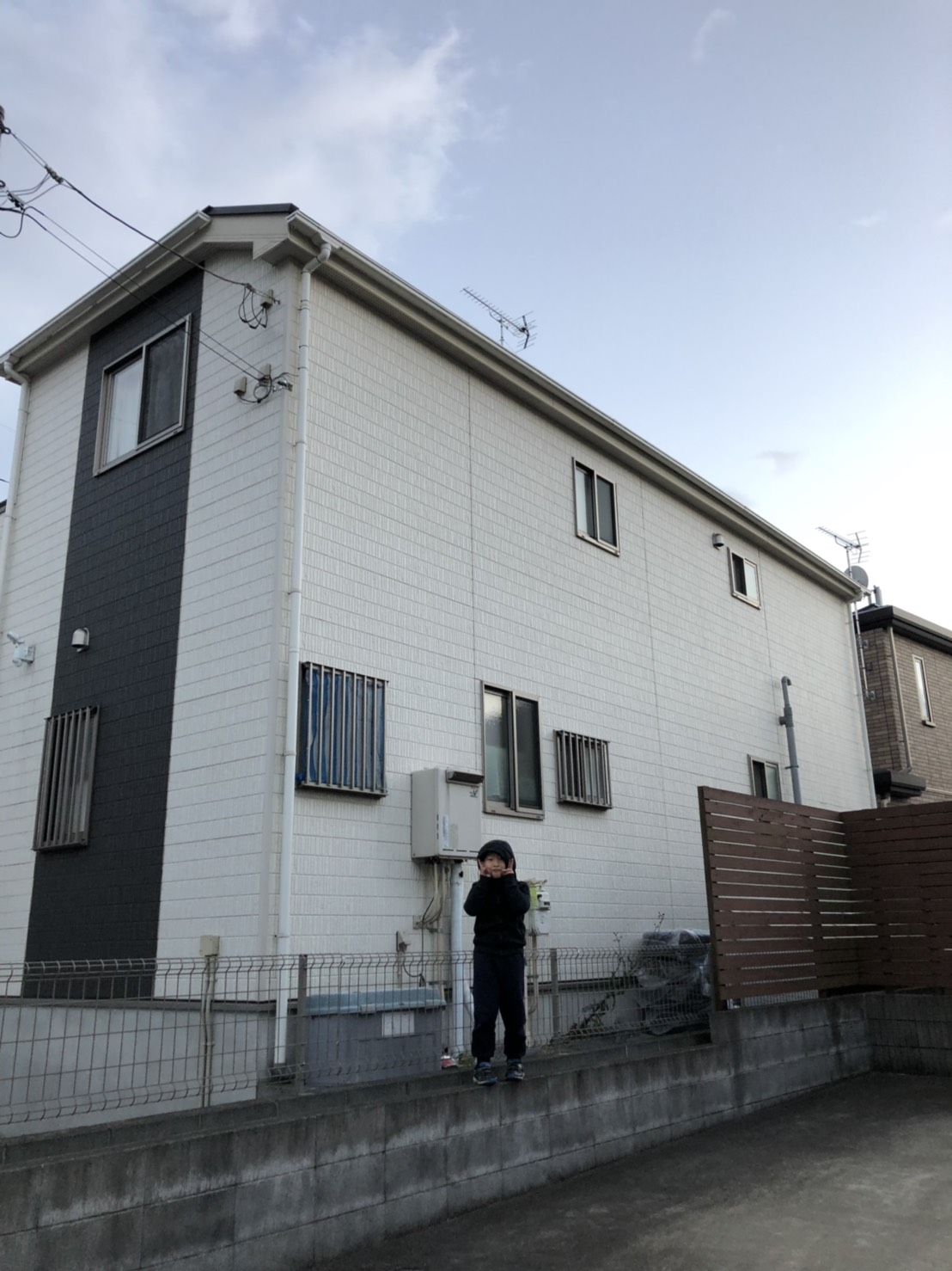 戸建住宅の前でポーズをとる子供