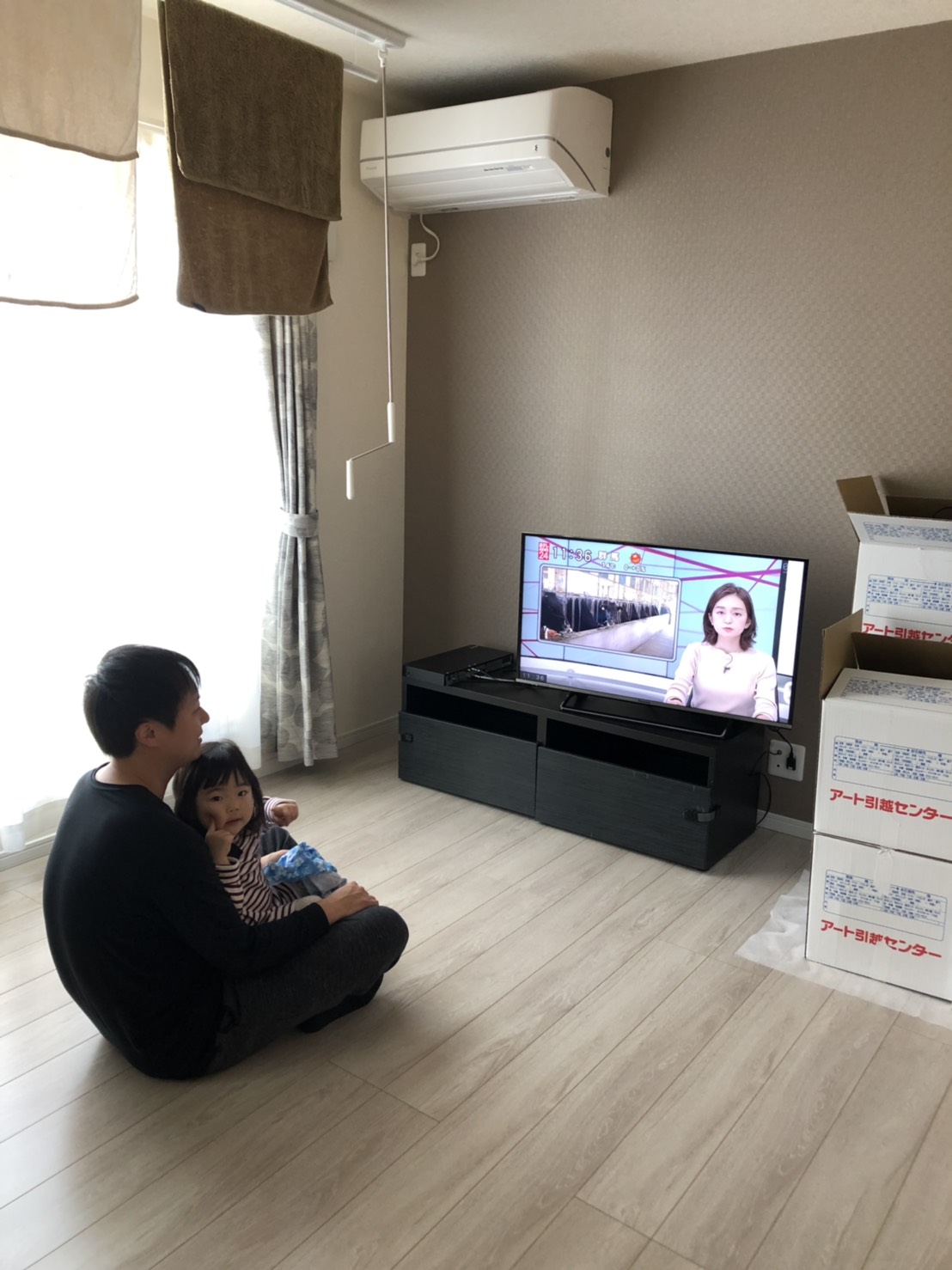 床に座ってテレビを見ている親子