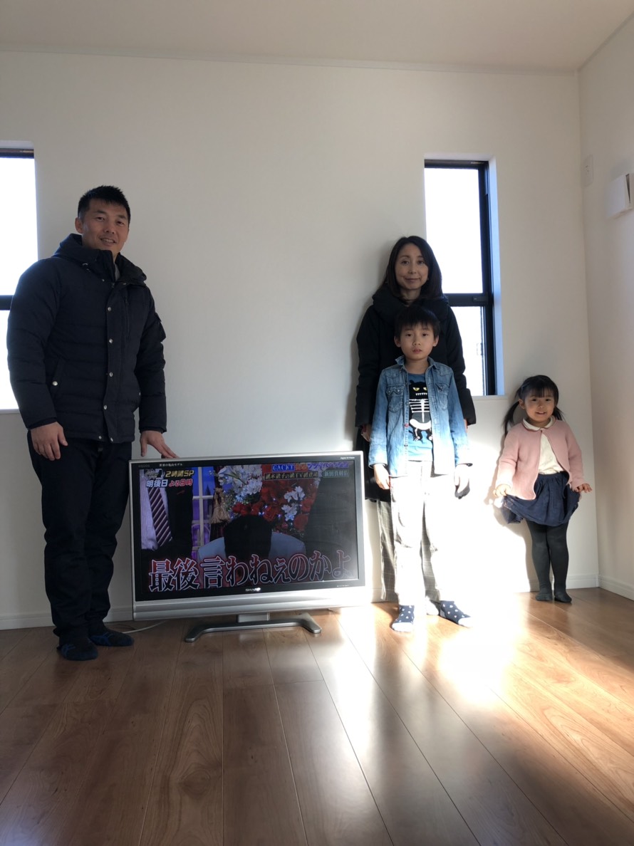 テレビの横に立つ家族