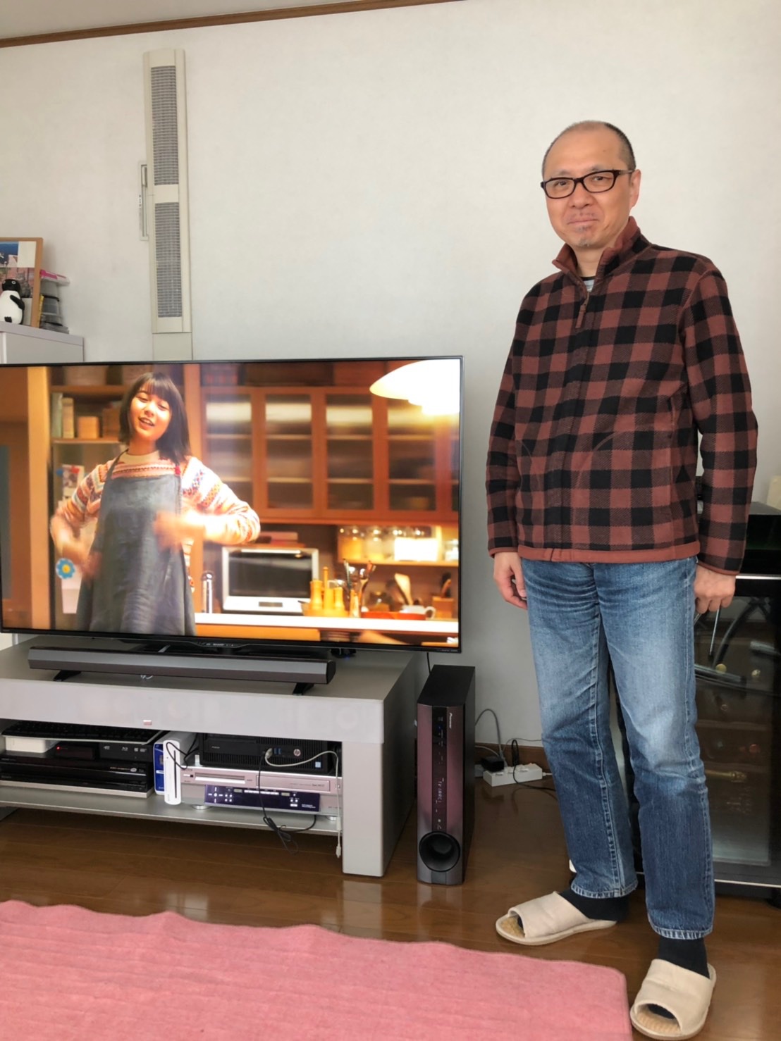 テレビ横に立つ男性