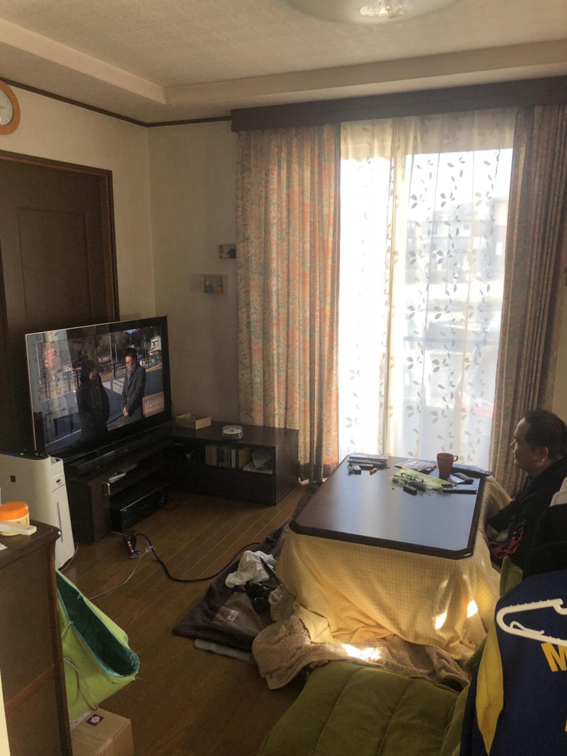 コタツでテレビを視聴する男性