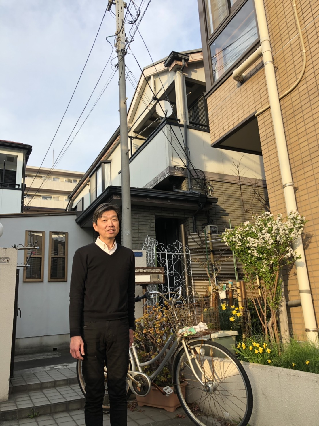 戸建住宅の前で撮影に応じる男性