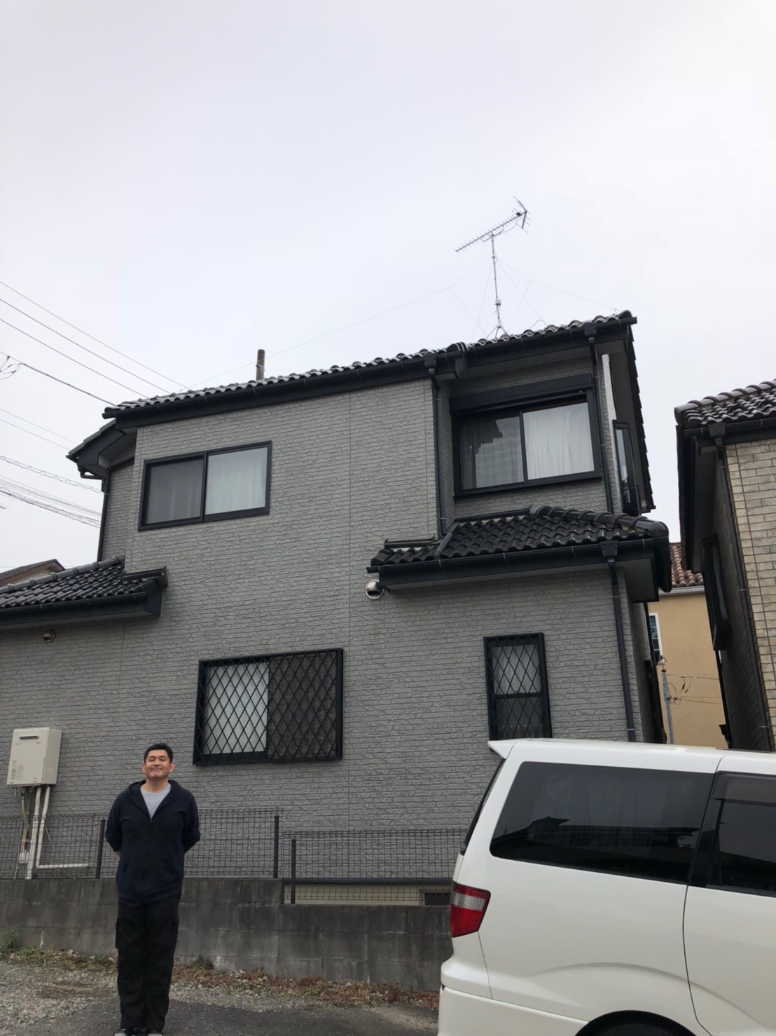 戸建住宅の前に立っている男性