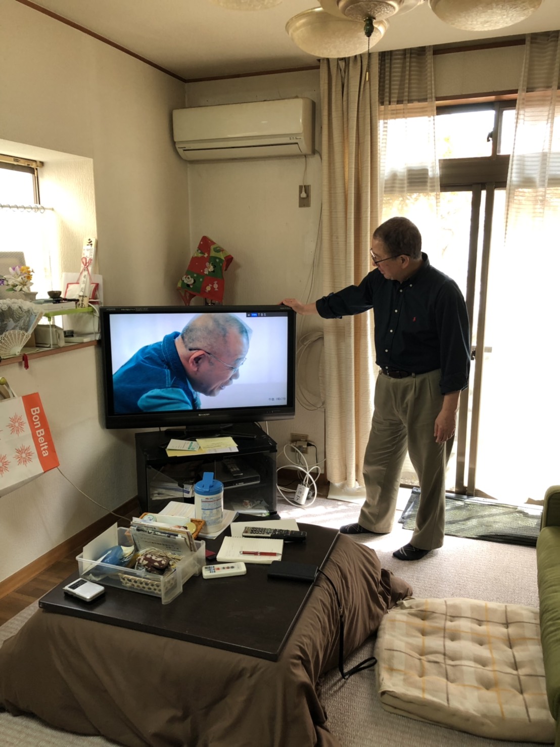 テレビ横の男性