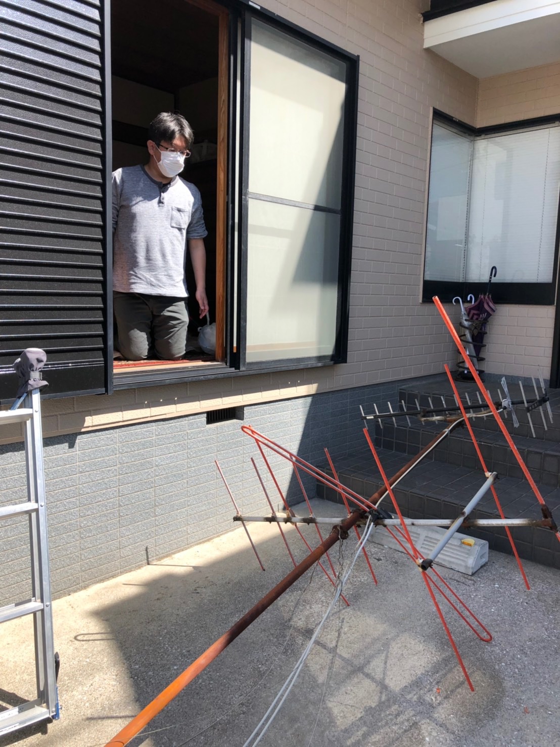 撤去したテレビアンテナを部屋から眺める男性