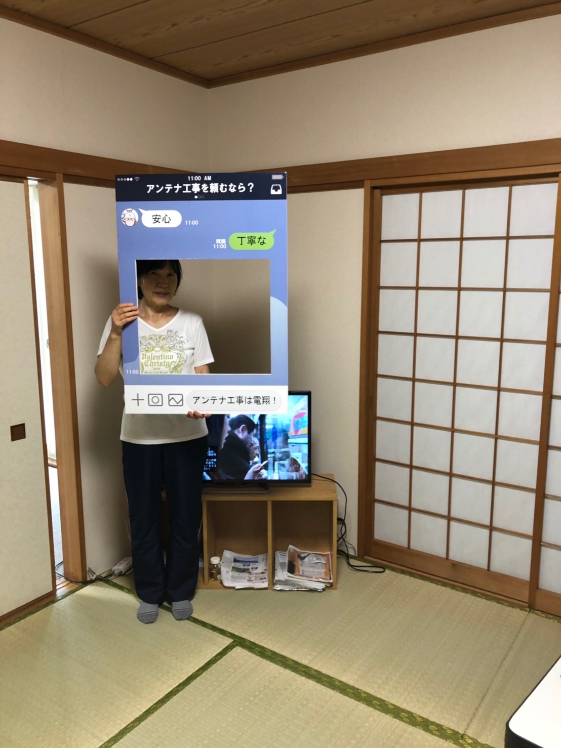 テレビ前でパネルを持つ女性