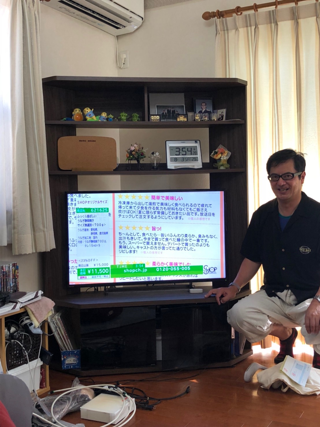 テレビの横にしゃがんでいる男性