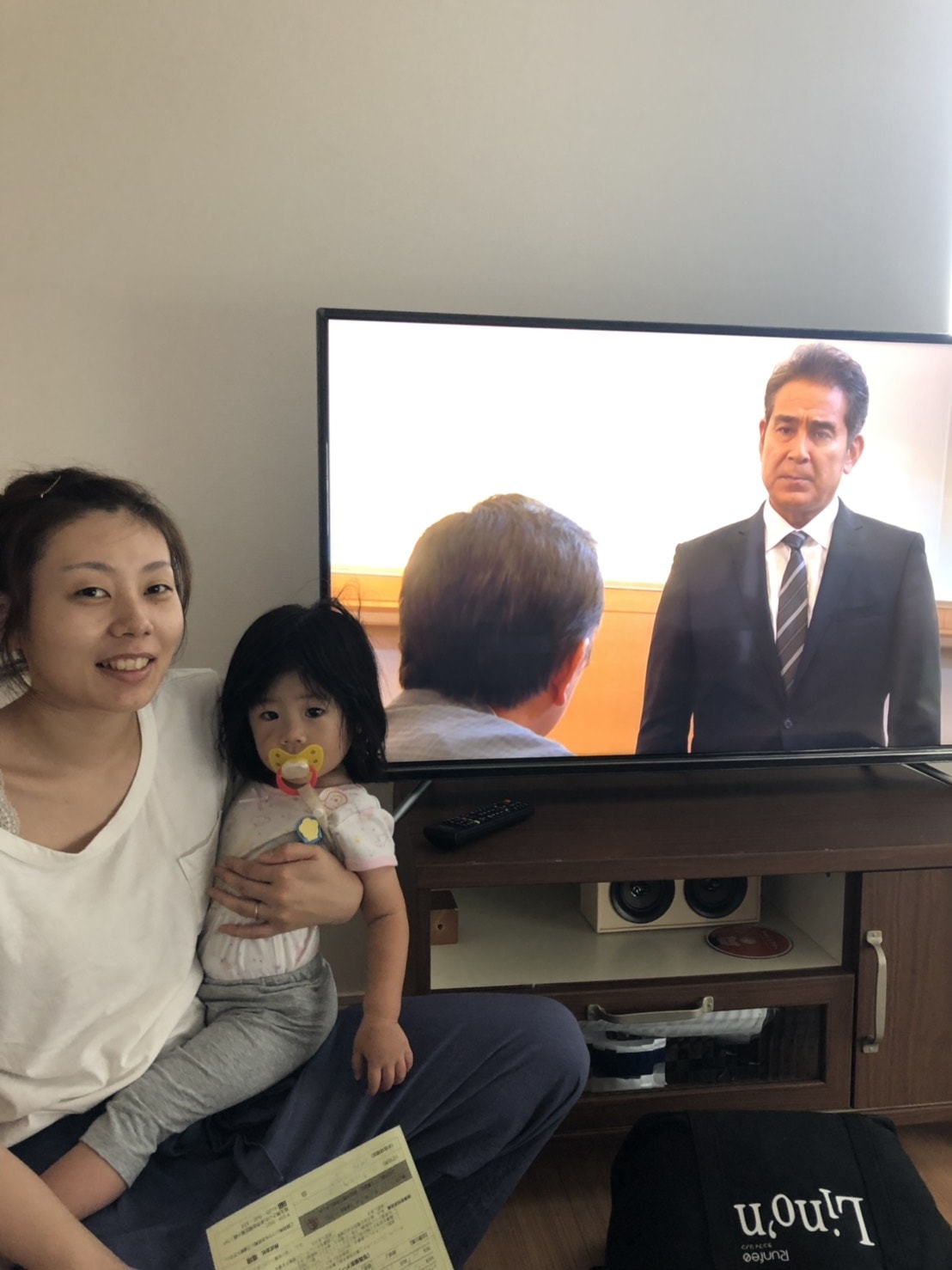テレビ横で撮影に応じる親子