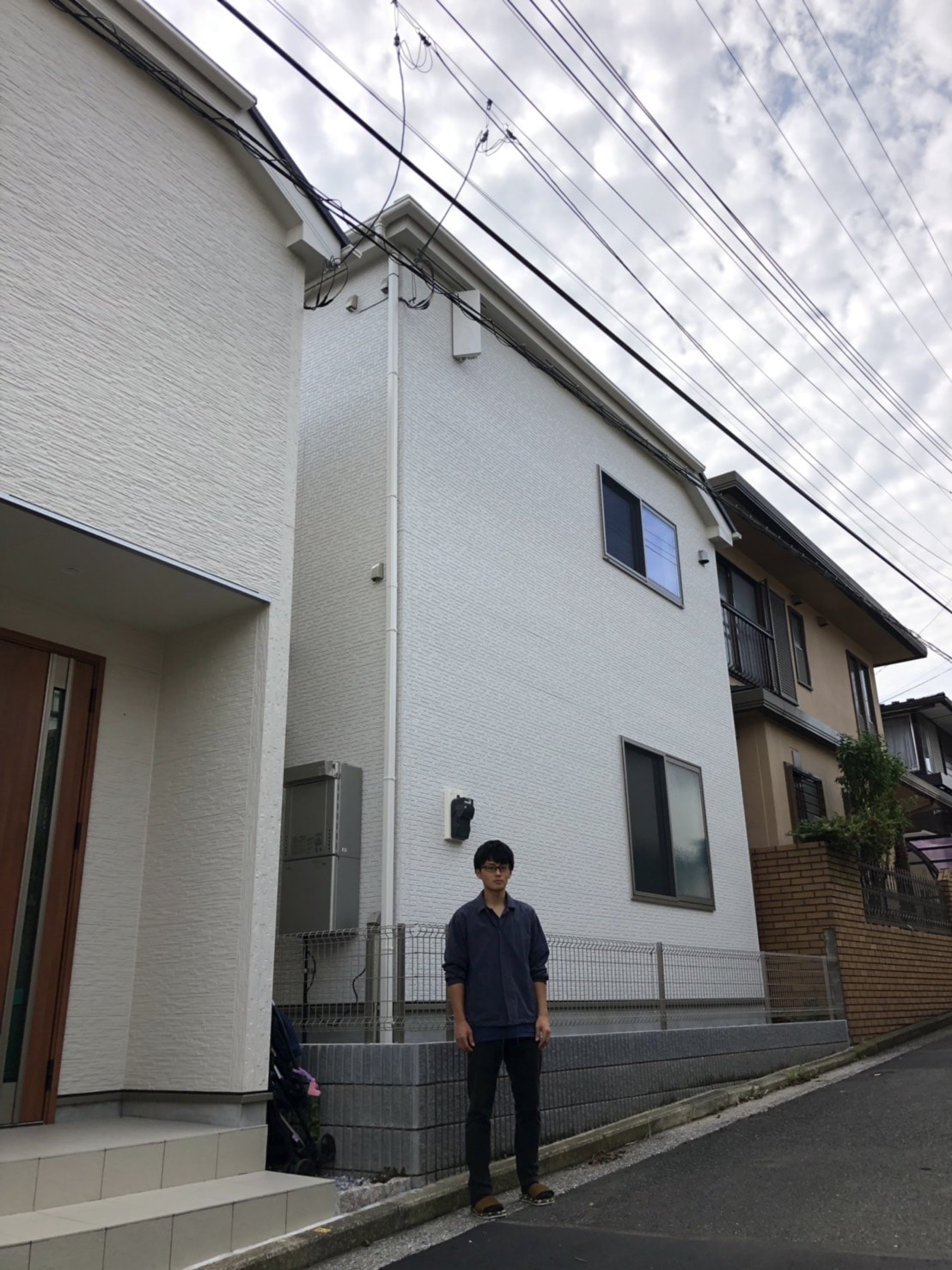 デザインアンテナを設置した住宅前に立つ男性