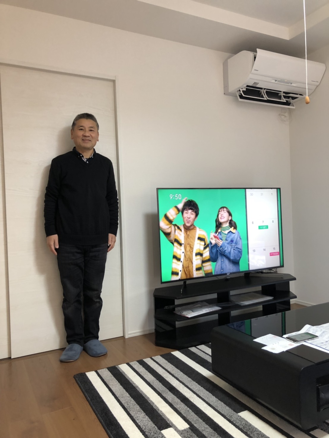 テレビの横に立つ男性
