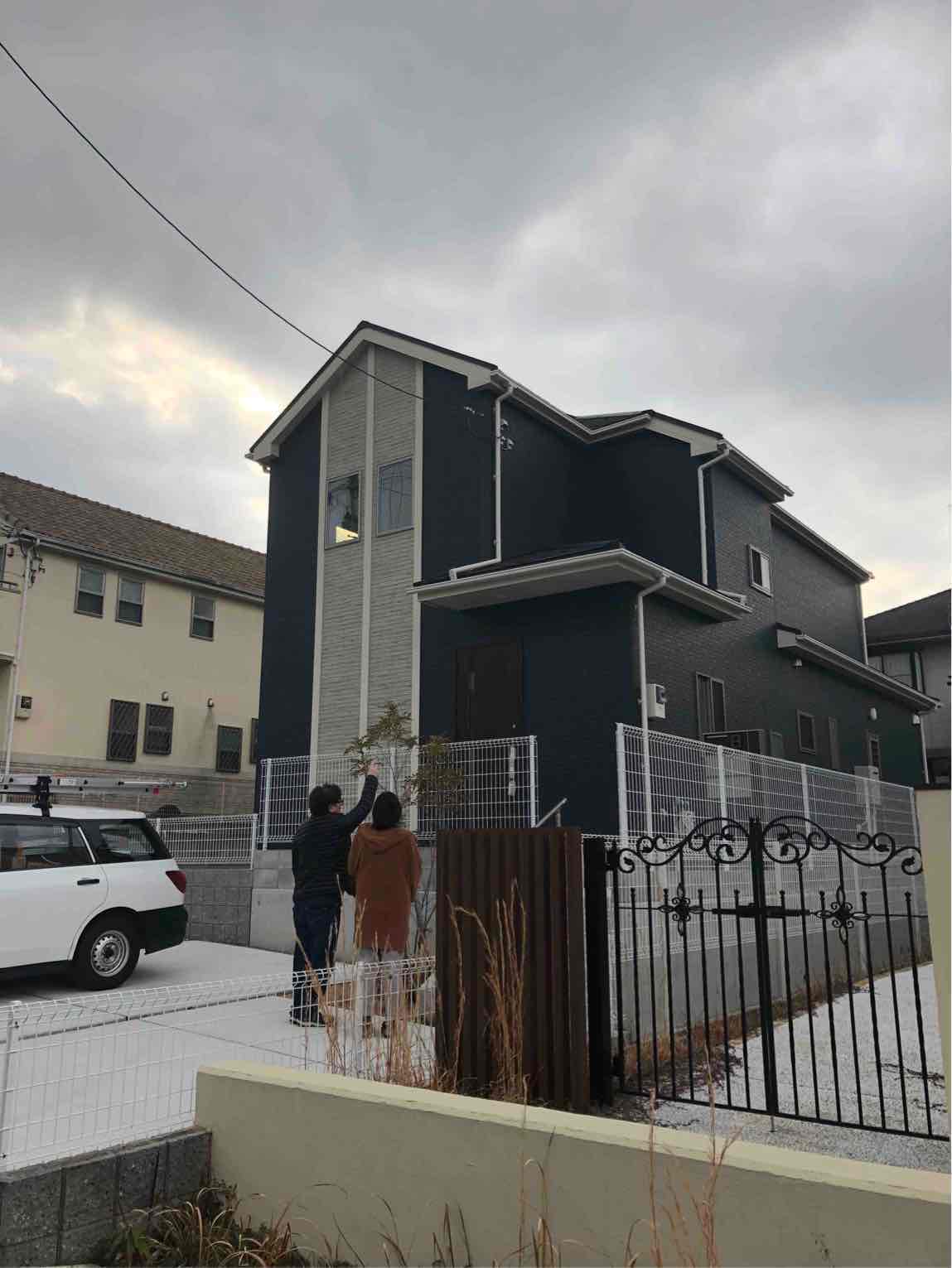 戸建住宅を指さす夫婦