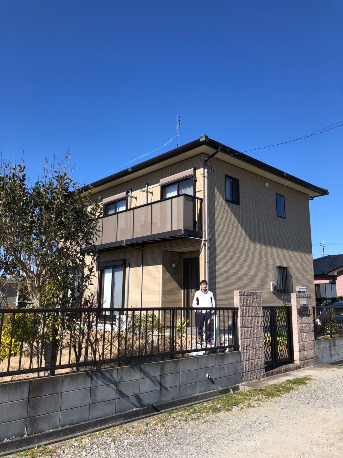 UHFアンテナを設置した戸建住宅の前に立つ男性