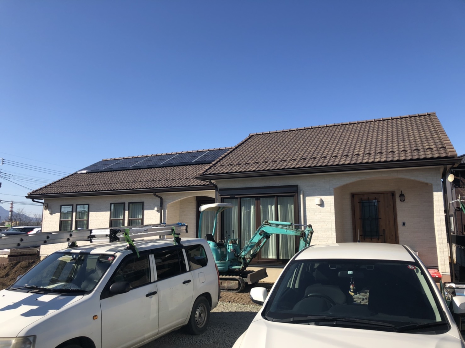 平屋住宅と敷地に停車した2台の自動車