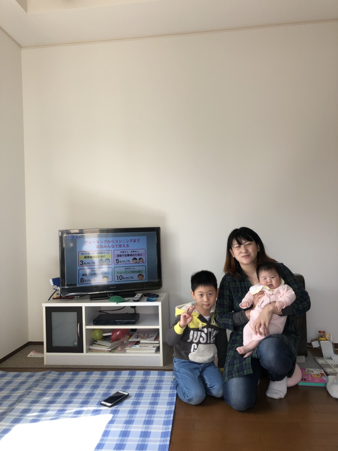 テレビ前で撮影に応じる家族