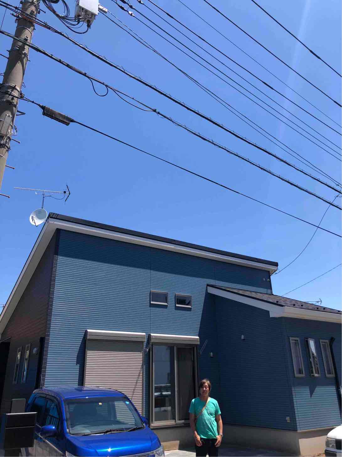 アンテナを設置した住宅の前に立つ男性