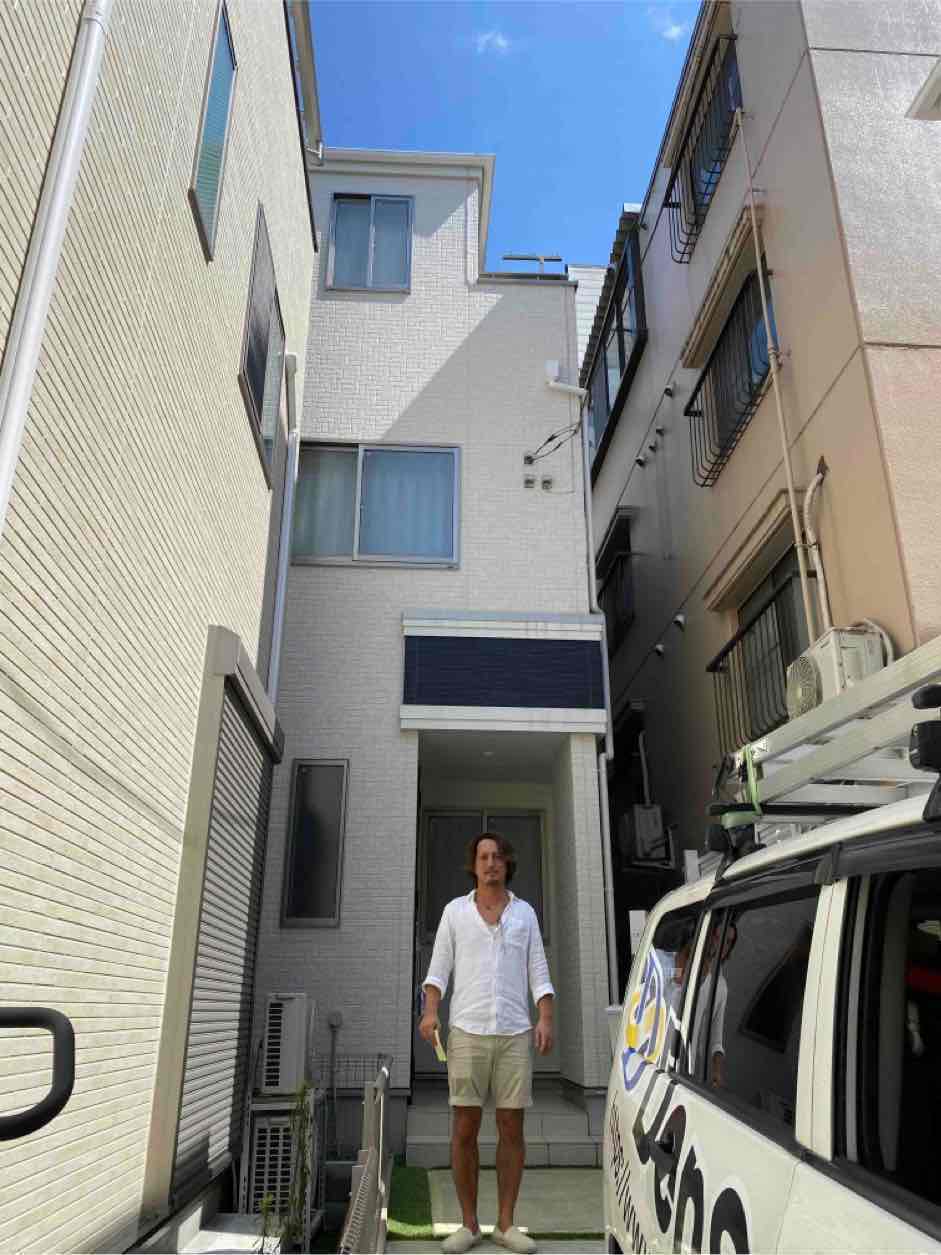 戸建住宅の前に立つ男性