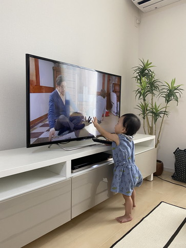 テレビに手を伸ばす幼児